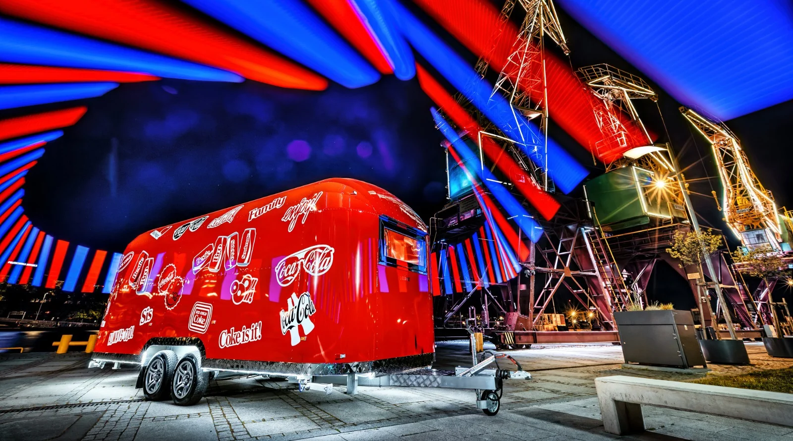 Przyczepa promocyjna wyprodukowana przez firmę SHINE, przyczepa jest w czerwonym kolorze oraz posiada grafikę reklamową marki Coca Cola
